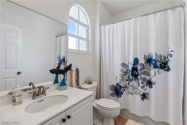 bathroom with tile flooring, toilet, and vanity with extensive cabinet space