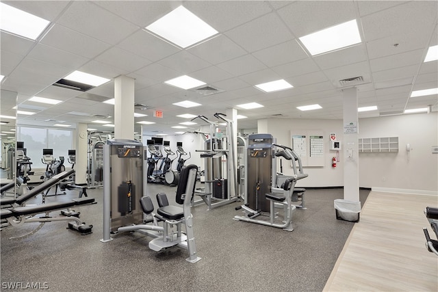 gym with a drop ceiling and hardwood / wood-style flooring