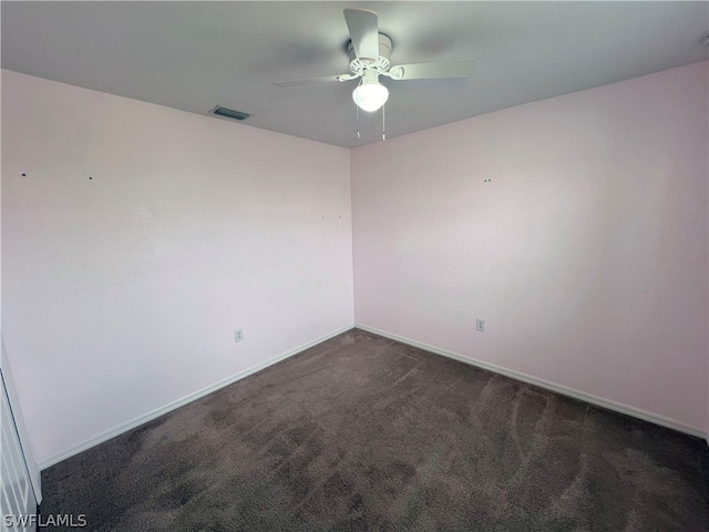 spare room with dark carpet and ceiling fan