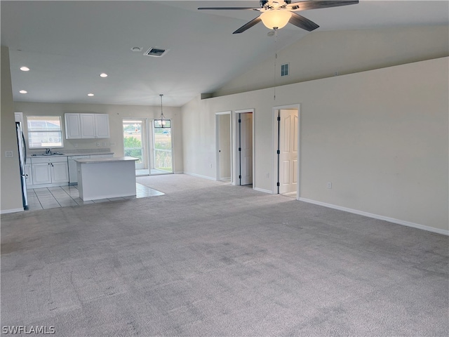 unfurnished living room featuring light colored carpet, ceiling fan, and high vaulted ceiling