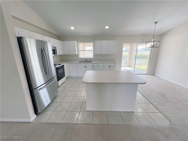 kitchen featuring a kitchen island, appliances with stainless steel finishes, a chandelier, light carpet, and white cabinetry