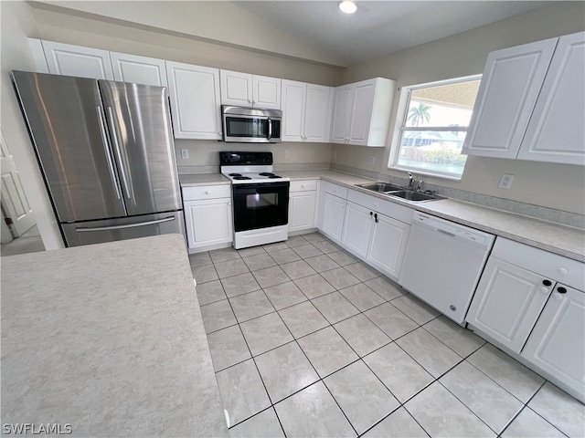 kitchen featuring sink, light tile floors, appliances with stainless steel finishes, and white cabinetry