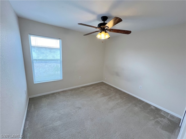 carpeted spare room with ceiling fan