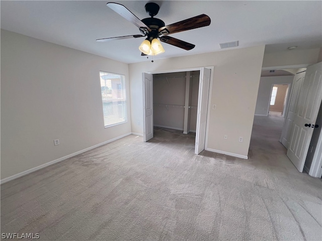 unfurnished bedroom with a closet, light carpet, and ceiling fan