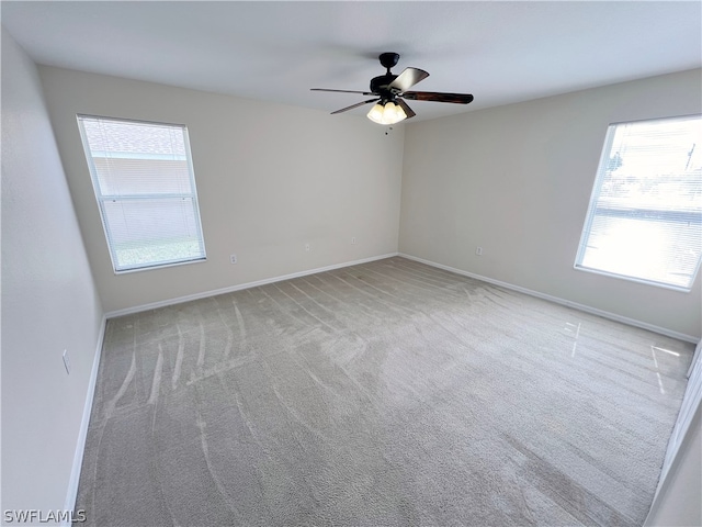 carpeted empty room with a healthy amount of sunlight and ceiling fan