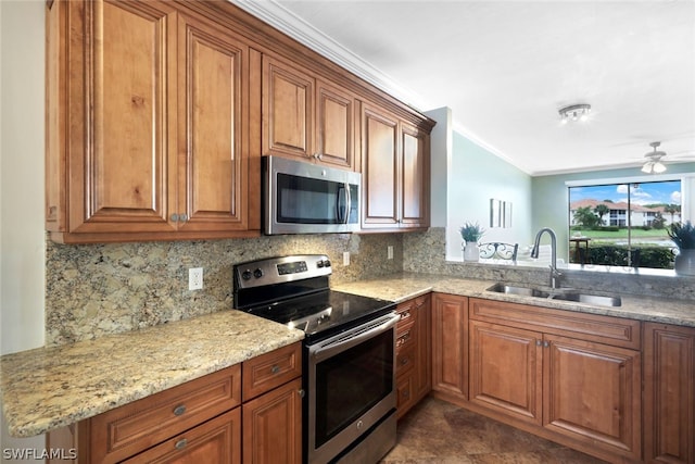 kitchen featuring appliances with stainless steel finishes, sink, dark tile patterned flooring, light stone countertops, and ceiling fan