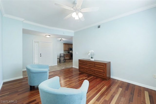 living room featuring crown molding, dark wood-type flooring, and ceiling fan