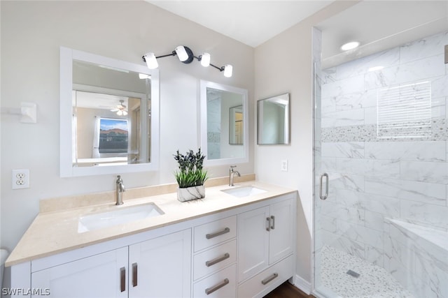 bathroom with ceiling fan, dual vanity, and an enclosed shower