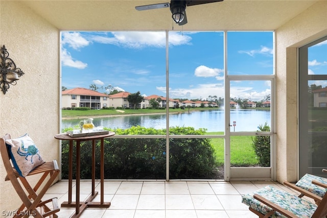 unfurnished sunroom with a water view and ceiling fan