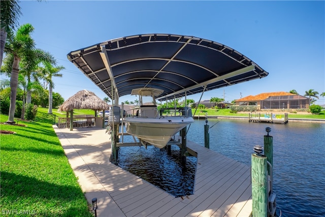 view of dock with a lawn, a water view, and a lanai