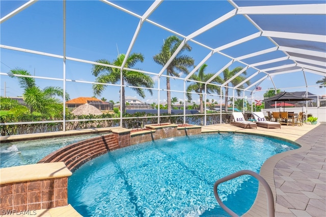 view of pool with a patio area, a lanai, and pool water feature