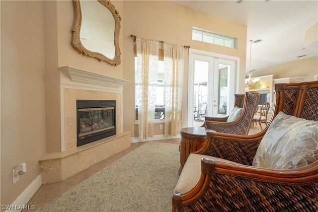 sitting room with light tile floors, french doors, and a fireplace