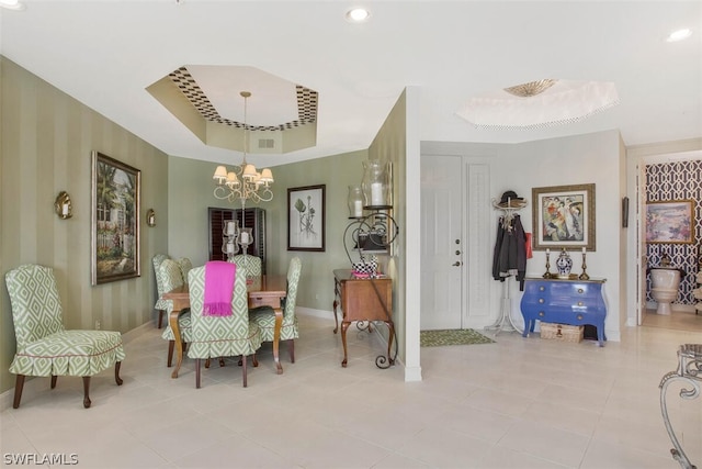 dining room featuring light tile patterned floors, a raised ceiling, and an inviting chandelier