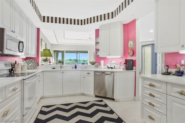 kitchen featuring light stone counters, sink, white cabinetry, and appliances with stainless steel finishes