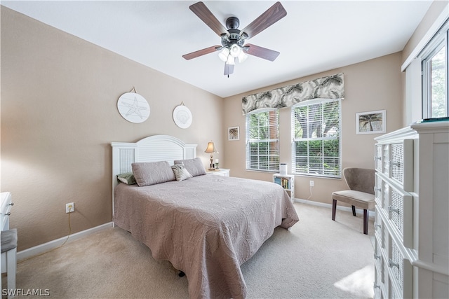 bedroom with light carpet, multiple windows, and ceiling fan