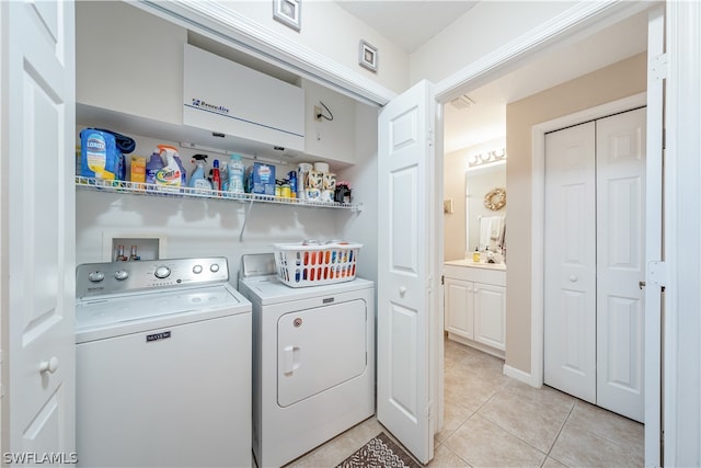 washroom featuring hookup for a washing machine, washing machine and dryer, and light tile floors