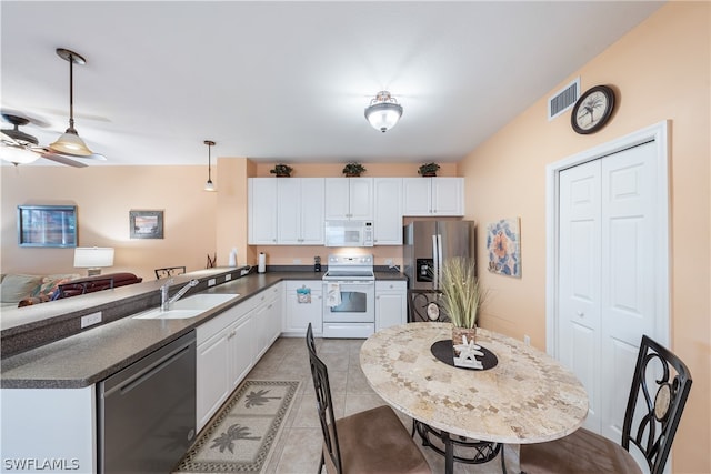 kitchen featuring decorative light fixtures, ceiling fan, stainless steel appliances, light tile floors, and white cabinets