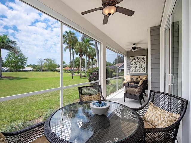 sunroom / solarium featuring ceiling fan