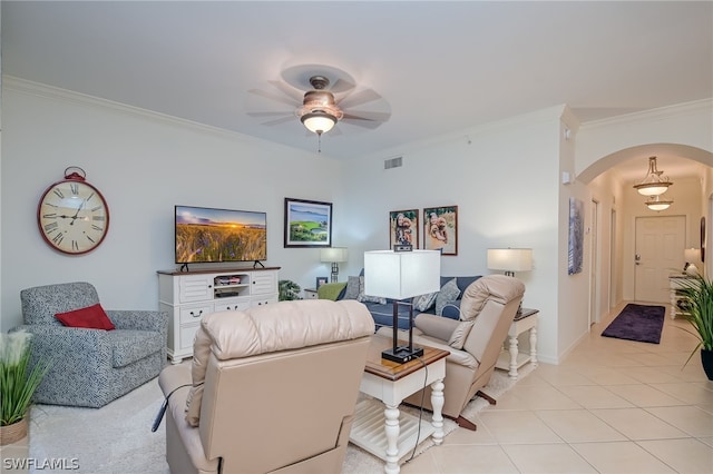 living room featuring light tile floors, ceiling fan, and ornamental molding