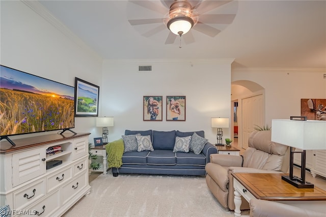 living room with light carpet, ornamental molding, and ceiling fan