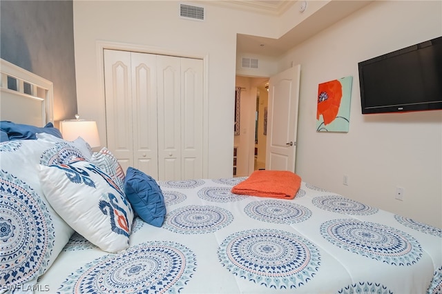 bedroom with ornamental molding and a closet