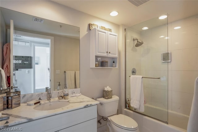 full bathroom with shower / bath combination with glass door, toilet, and vanity