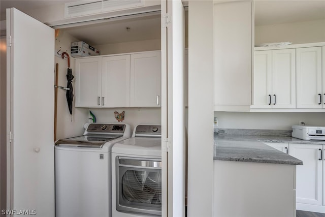 laundry area featuring washing machine and dryer and cabinets