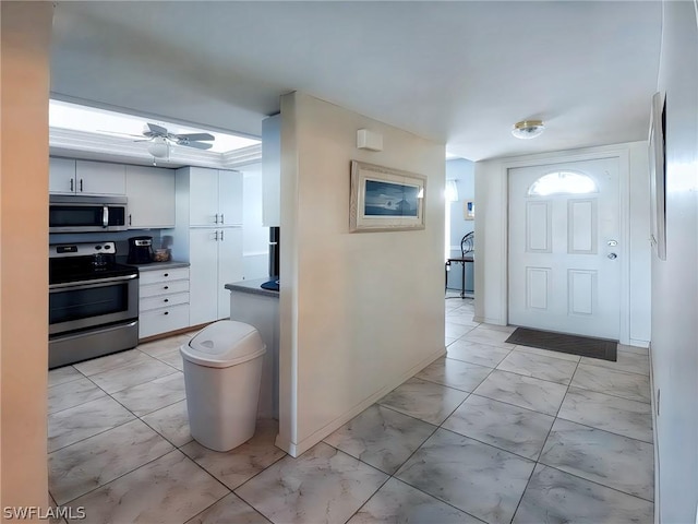 kitchen featuring ceiling fan, white cabinetry, and stainless steel appliances