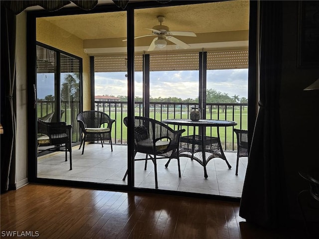 sunroom / solarium featuring ceiling fan