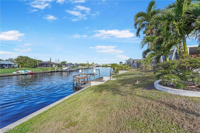 dock area with a lawn and a water view