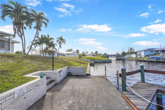 dock area featuring a water view and a yard