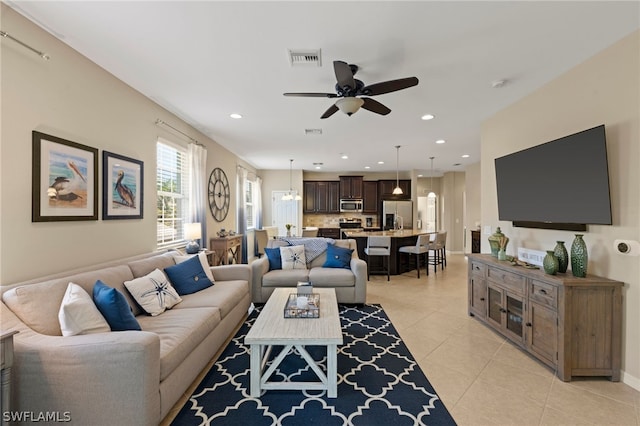 living room with light tile flooring and ceiling fan with notable chandelier