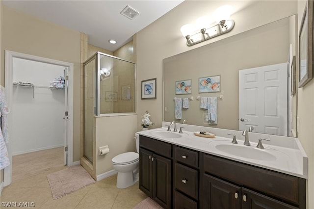 bathroom featuring a shower with shower door, oversized vanity, tile floors, and dual sinks