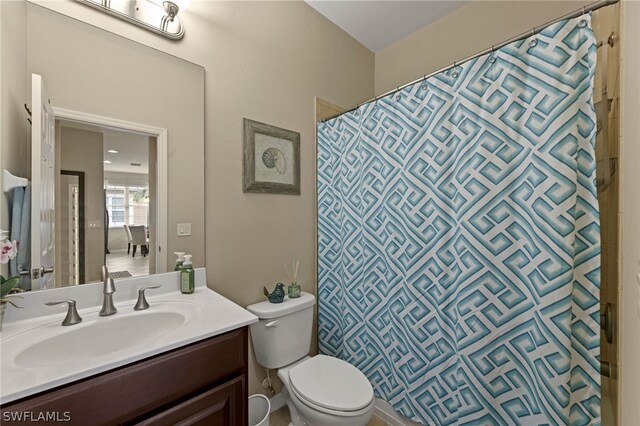 bathroom featuring vanity with extensive cabinet space and toilet