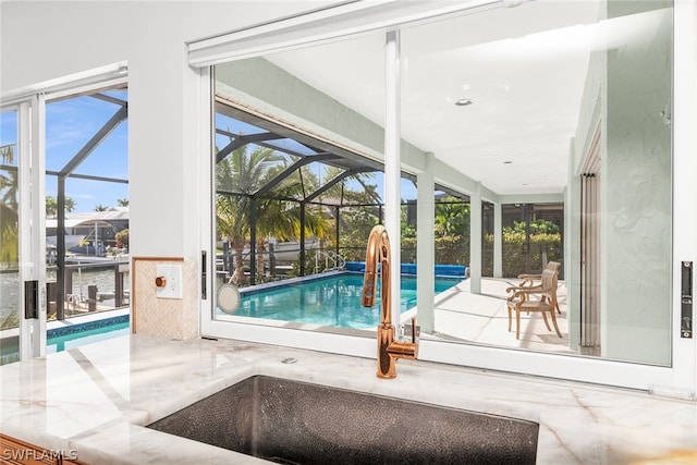 view of pool featuring a lanai, sink, and a patio