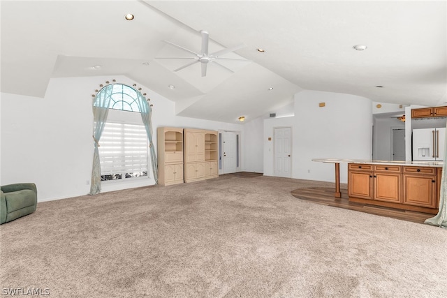 unfurnished living room with vaulted ceiling, light colored carpet, and ceiling fan