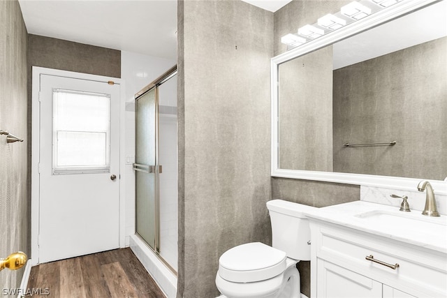 bathroom with an enclosed shower, oversized vanity, hardwood / wood-style floors, and toilet