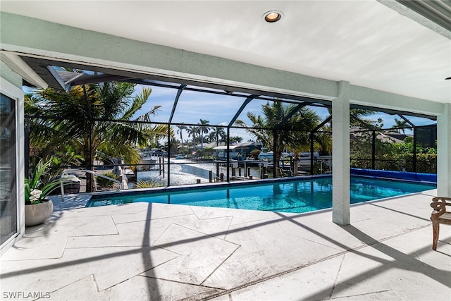 view of swimming pool with glass enclosure and a patio