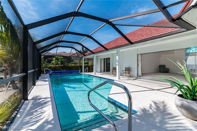 view of pool with a patio area and glass enclosure