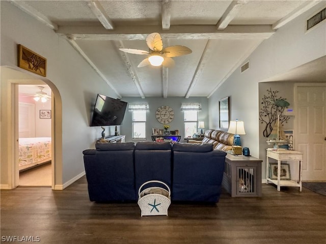 living room with ceiling fan, dark hardwood / wood-style flooring, lofted ceiling with beams, and a textured ceiling