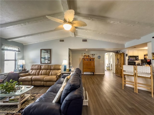 living room with a textured ceiling, dark hardwood / wood-style flooring, lofted ceiling with beams, and ceiling fan