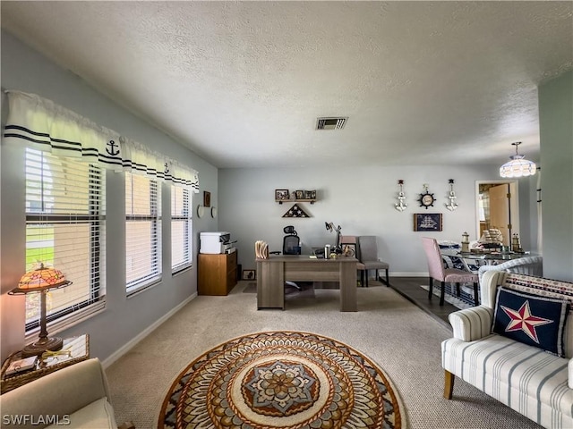 office area with carpet floors and a textured ceiling