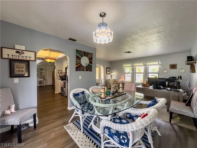 dining space featuring dark hardwood / wood-style floors and a textured ceiling