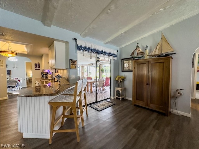 kitchen featuring sink, white cabinets, dark wood-type flooring, and a textured ceiling