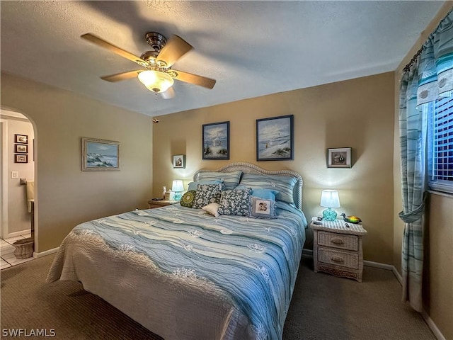 carpeted bedroom with ceiling fan and a textured ceiling