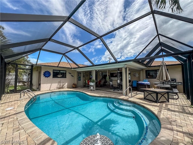 view of swimming pool featuring glass enclosure, ceiling fan, and a patio