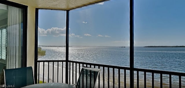 unfurnished sunroom with a water view