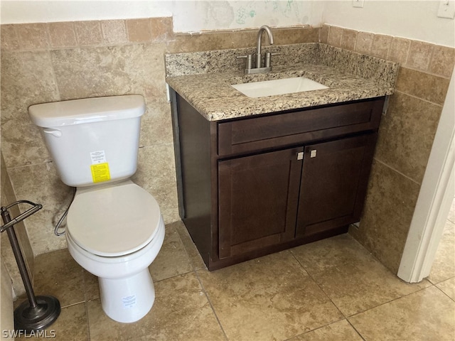 bathroom with tile walls, tile floors, toilet, and vanity