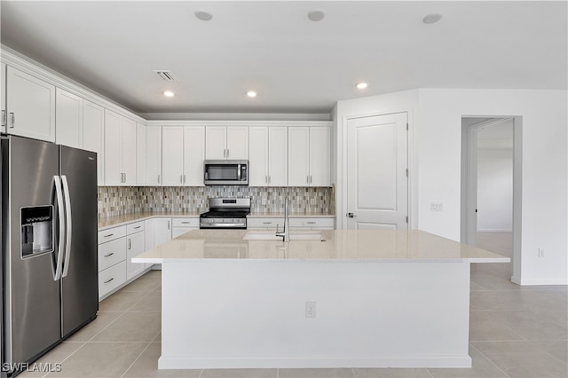 kitchen featuring white cabinets, an island with sink, and stainless steel appliances