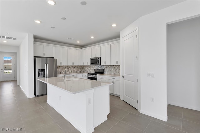 kitchen featuring stainless steel appliances, sink, an island with sink, white cabinetry, and light tile patterned flooring